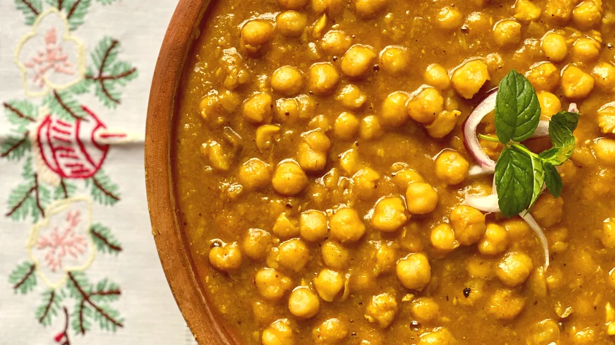Un cocido de legumbres y verdura servido en un plato hondo.