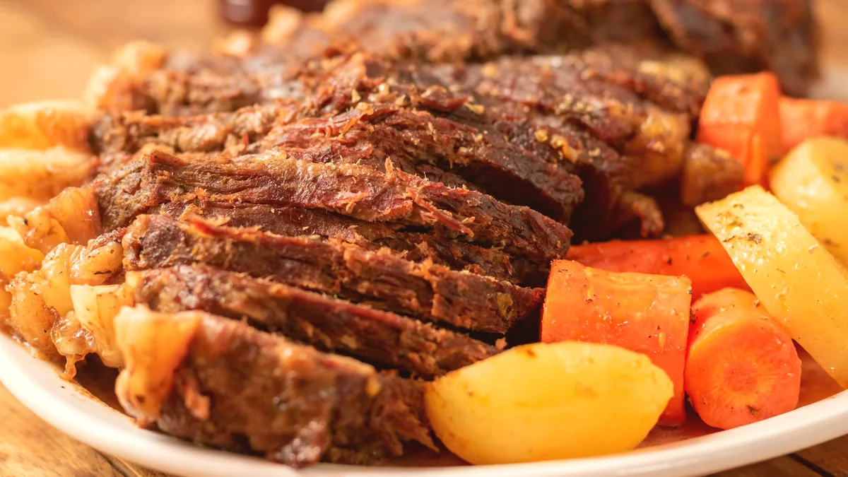 Carne mechada guisada y cortada en lonchas finas y servida en un plato.