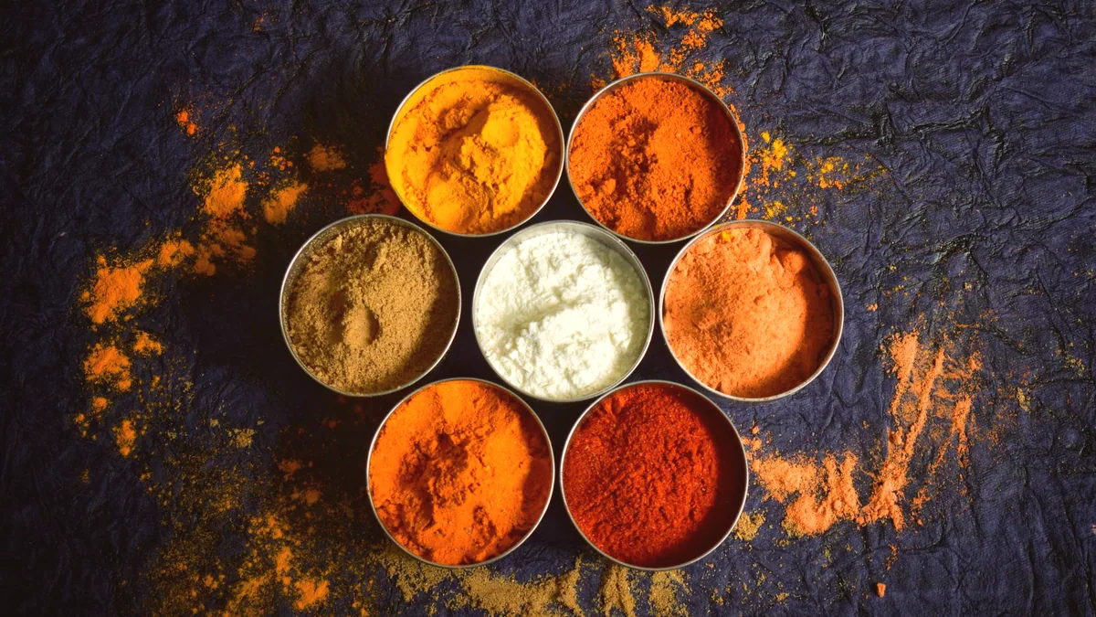 Las especias del adobo, pimentón, comino, orégano y ajo, en cuencos sobre la mesa.