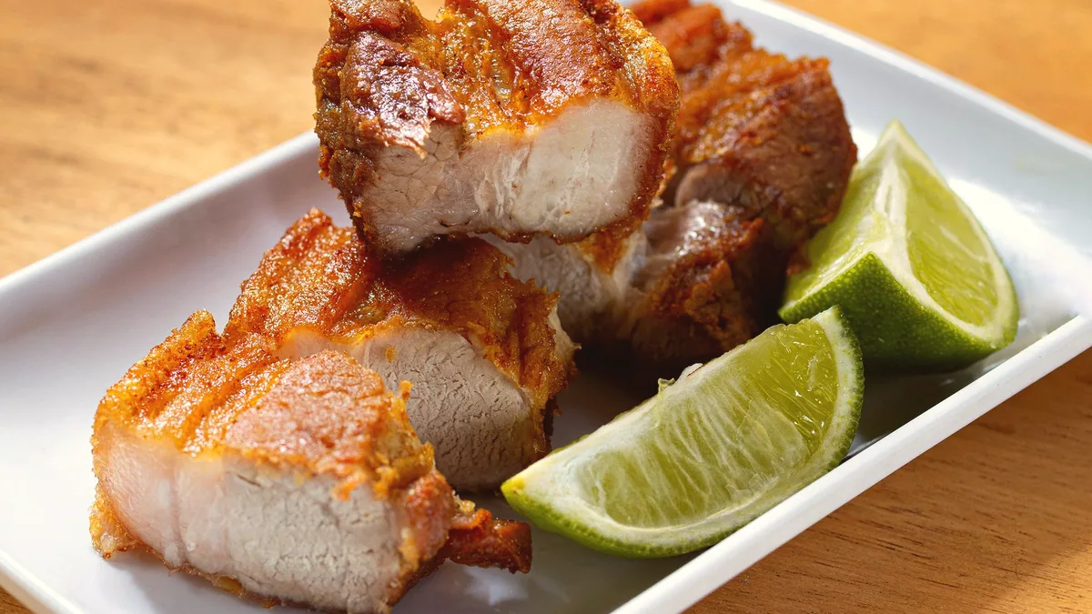 Lonchas finas de panceta de cerdo cocinada, servidas frias.