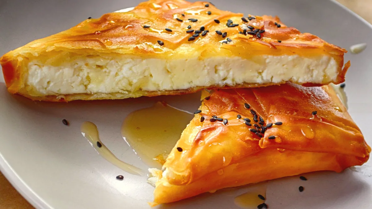 Dulces de sarten banados en miel, apilados en un plato.
