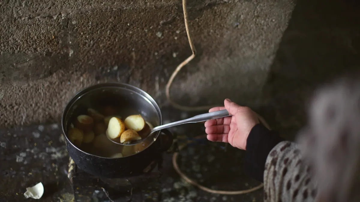 Un guiso de patatas en una olla, caldoso y espeso.