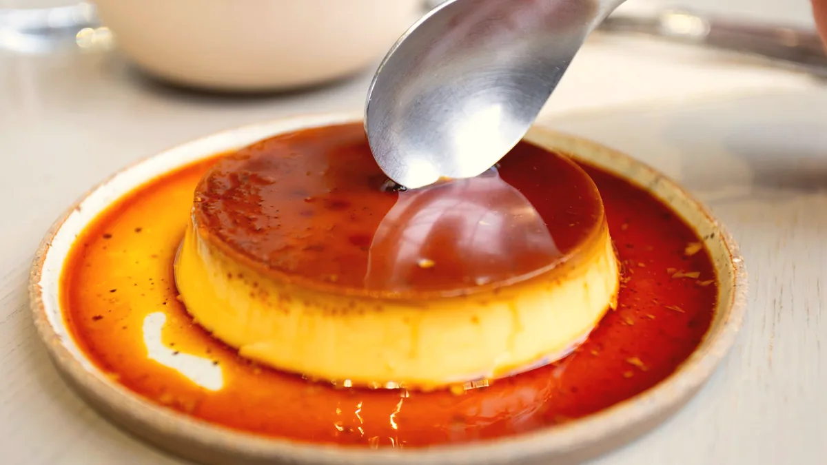 Un postre de yema cuajada con caramelo por encima.